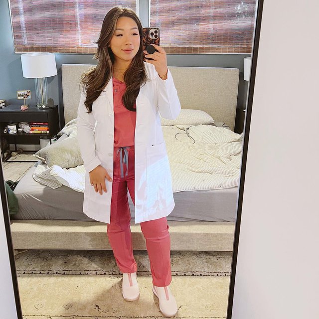 Celebrating being officially 1 month out from starting my new job as a gynecology NP + I’m full of ALL the emotions - anxious, nervous, and excited! With a real life mirror pic - messy bedroom and all to prove it, wearing the white coat that I’ll realistically never wear, my favorite scrubs + Clara 1’s for the full effect 🥰