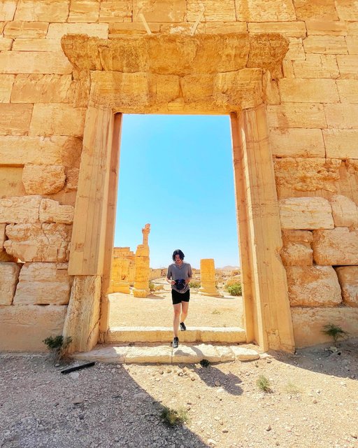 [Syria 🇸🇾 • Day 3: Site of Palmyra] Once the prosperous center of Syria thanks to trade caravans along the Silk Road, Palmyra is an ancient city of the Palmyrene Empire, a byproduct of secession from the Roman Empire. Dating back to the 3rd millennium B.C.E., Palmyra is known for its intricate architectural structures, including the Temple of Bel, the Agora, and the Great Colonnade. 🏛️

In 2015, most of the city was left in ruins by terrorist attacks, to which the United Nations confirmed the temple’s destruction. Seeing the broken columns and excavated Valley of the Tombs, you cannot help but feel an initial sense of regret for losing so much of tangible history. But walking through the desert’s open and empty spaces of what used to be a marketplace filled with so much transaction and population, I am reminded that the definition of history is the honor and stories that continue to live on despite any physical devastation. 

The name ‘Palmyra’ roots from a word that describes the date palm trees that surroun